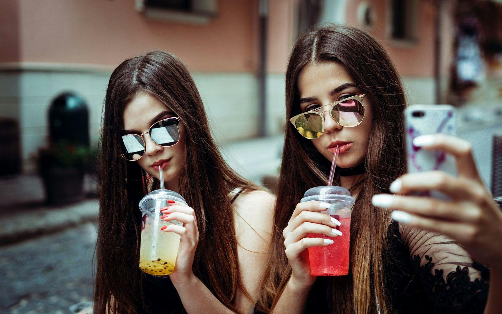 Tvillinger med solbriller som tar en selfie