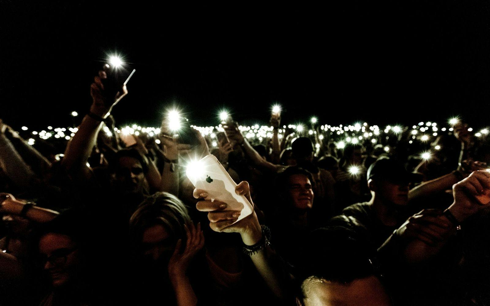 Et hav a smarttelefoner som lyser på en konsert